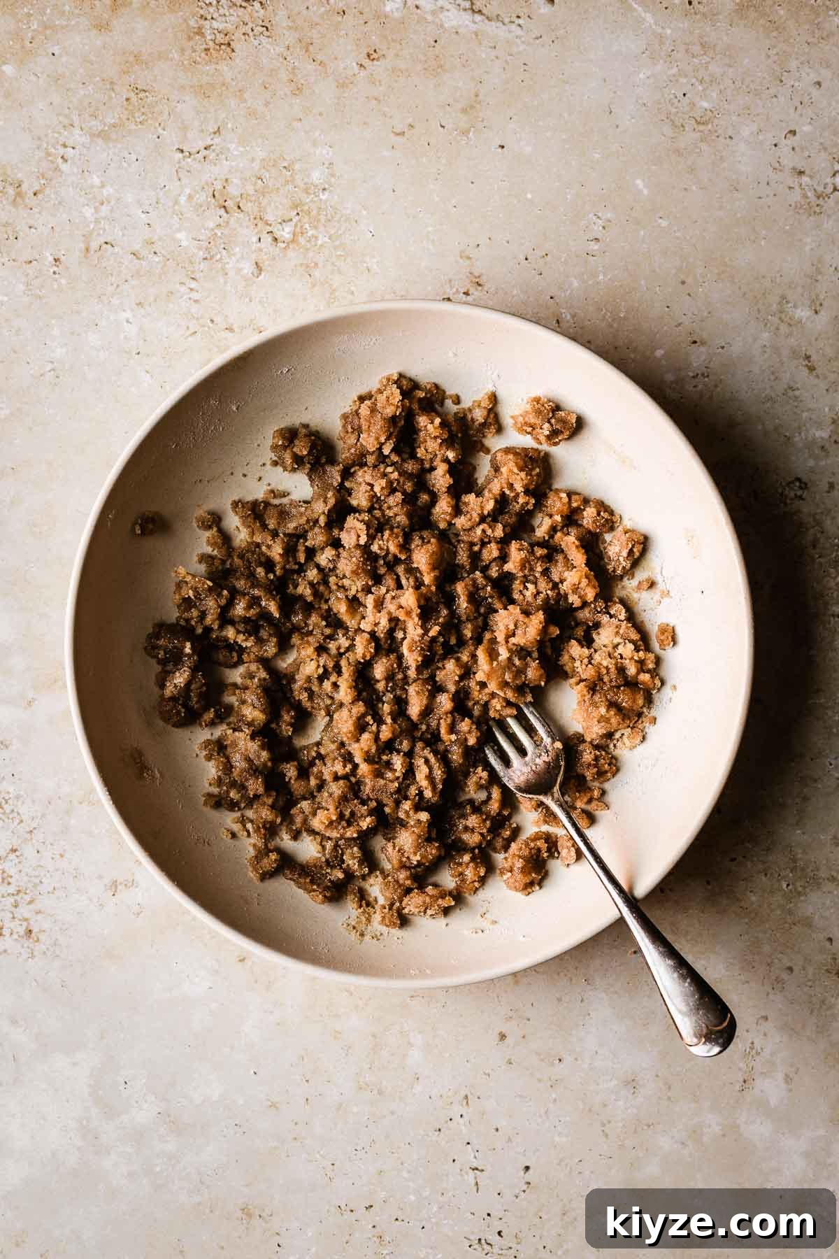 Cinnamon Streusel Muffins Recipe with Crunchy Brown Sugar Topping 5 A shallow tan bowl with streusel topping.