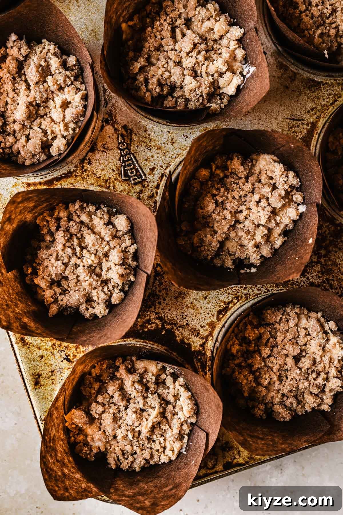 Cinnamon Streusel Muffins Recipe with Crunchy Brown Sugar Topping 10 Unbaked muffins covered in streusel topping.
