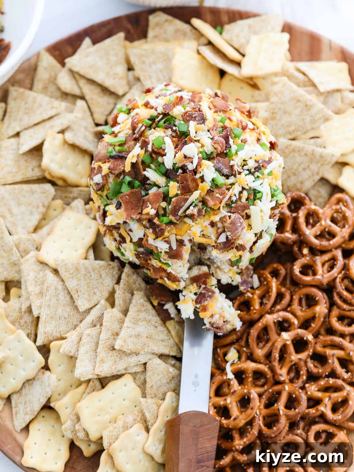 Savory Bacon Ranch Cheese Ball Recipe for Parties 7 Bacon Cheese Ball on platter with crackers and pretzels