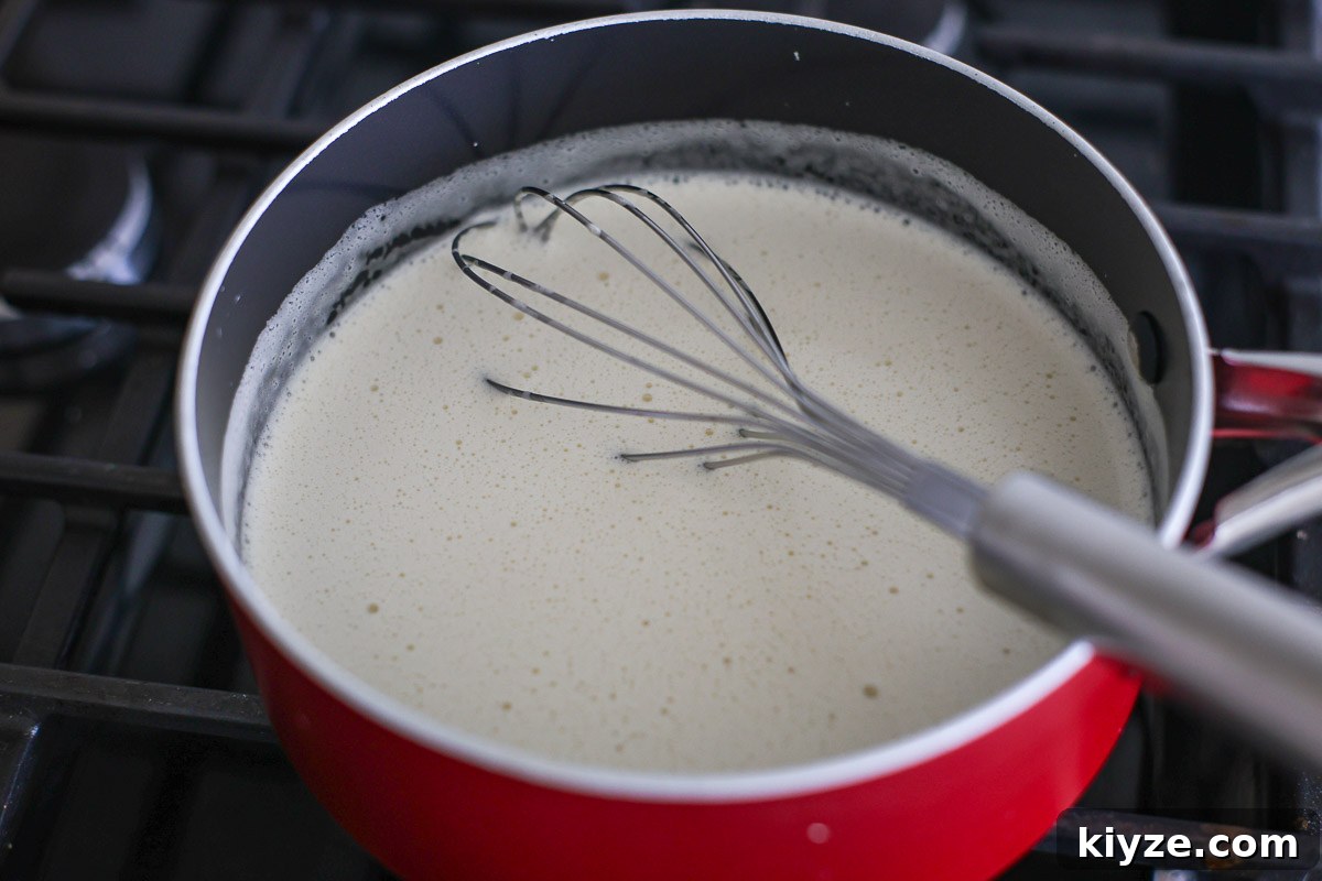 Earl Grey Custard Recipe: Silky Tea-Infused Pastry Cream 6 Cream mixture in a pan with whisk.