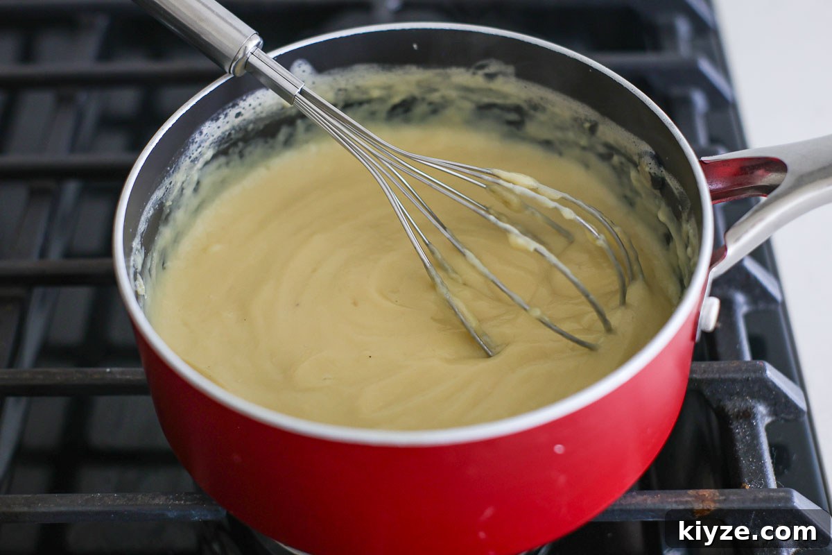 Earl Grey Custard Recipe: Silky Tea-Infused Pastry Cream 9 Custard ready in a pan with whisk.