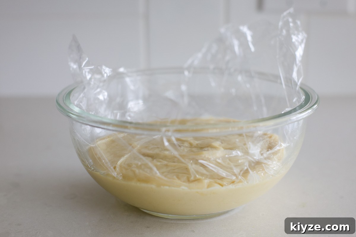 Earl Grey Custard Recipe: Silky Tea-Infused Pastry Cream 10 Custard in a glass bowl covered with plastic film.
