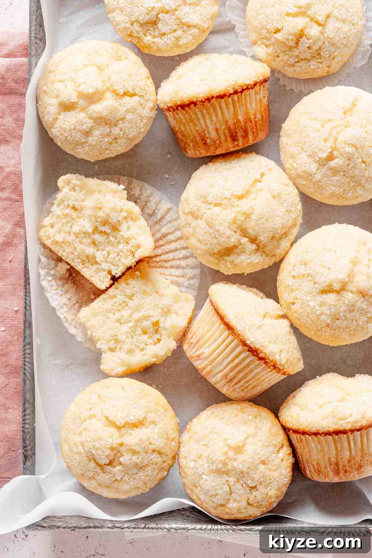 Fluffy Buttermilk Muffins Recipe for Tender Homemade Muffins 2 buttermilk muffins in tray lined with parchment paper.