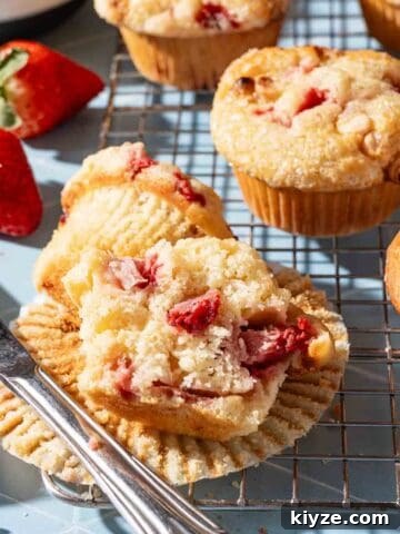 strawberry muffin cut in half with knife on the side.