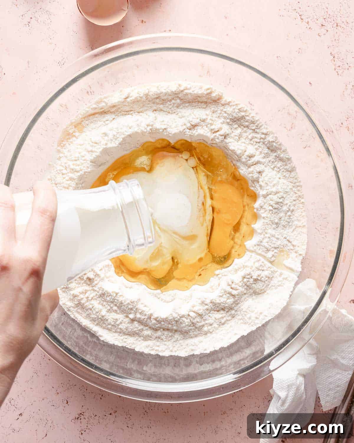 Fluffy Buttermilk Muffins Recipe for Tender Homemade Muffins 7 wet ingredients being added to well in center of muffin ingredients.