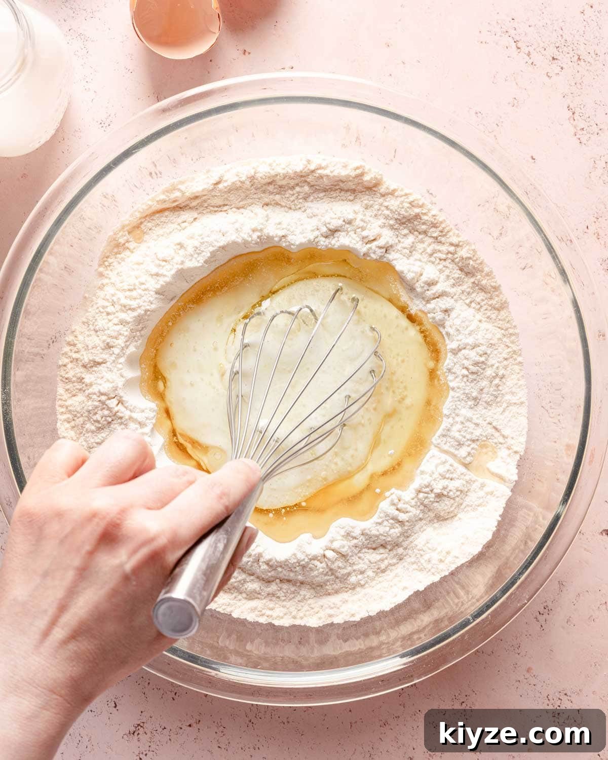 Fluffy Buttermilk Muffins Recipe for Tender Homemade Muffins 8 wet ingredients being whisked in center of well of dry ingredients.