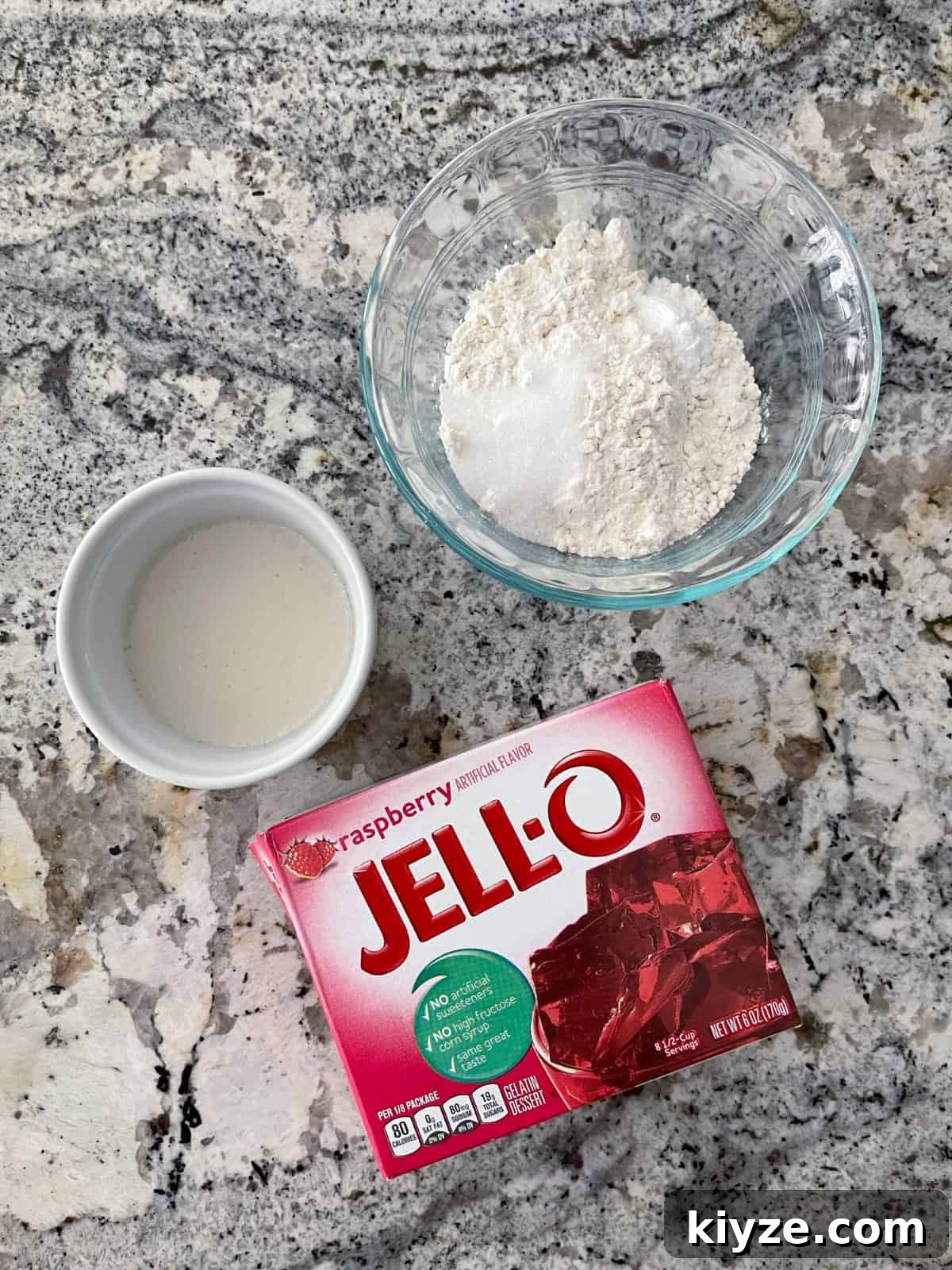 Microwave Mug Jello Cake Recipe: Quick Single-Serve Dessert 3 Ingredients including unsweetened almond milk, all-purpose flour, Swerve sweetener and raspberry Jell-o package.