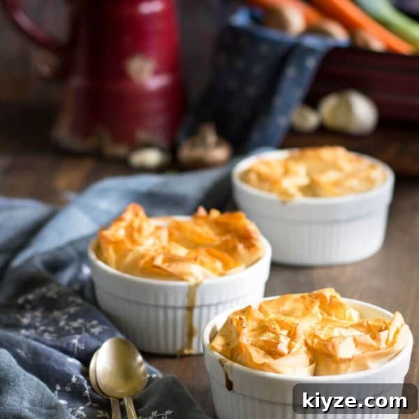 Crispy Fillo Vegetable Pot Pie with Savory Herb Filling 4 Individual pot pies with vegetables on a table with spoons.