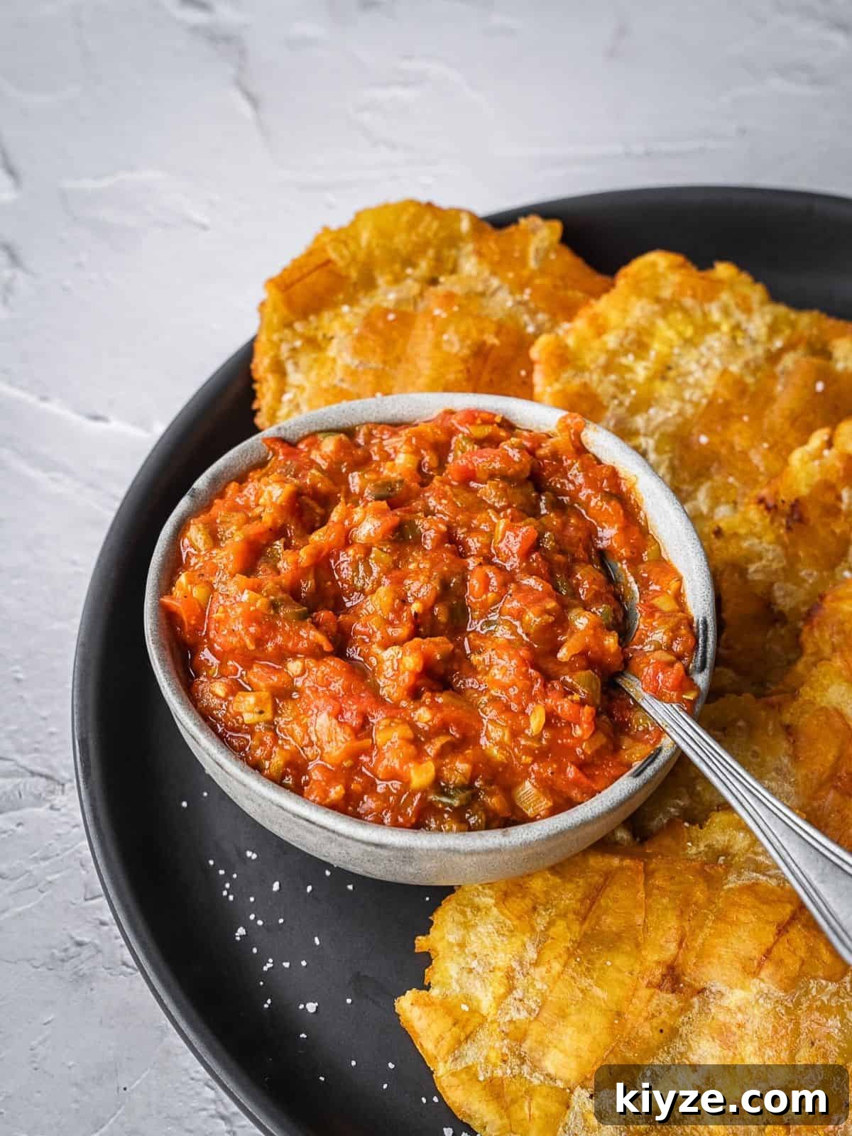 Hogao: Authentic Colombian Tomato and Scallion Creole Sauce Recipe 2 Colombian hogao sauce in a bowl surrounded by fried plantains.