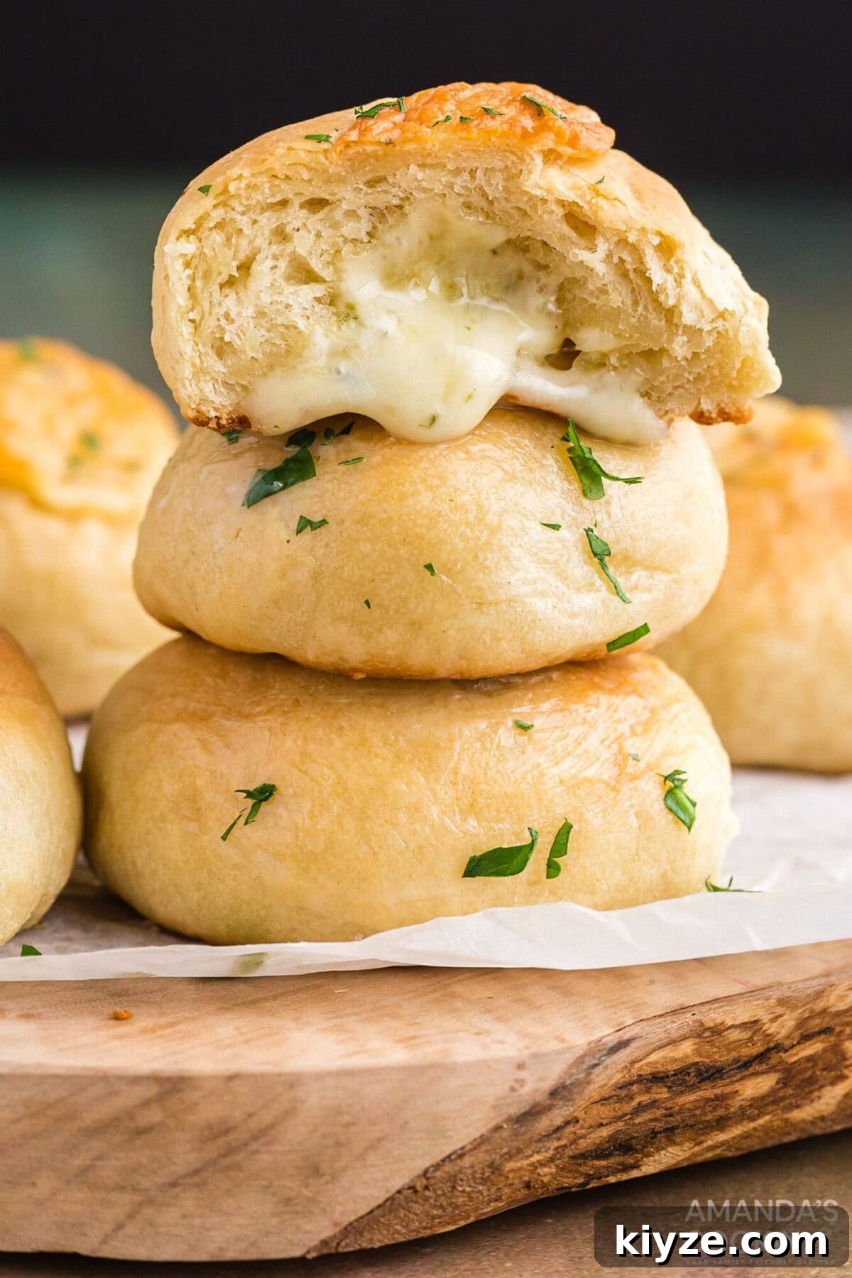 Garlic Herb Cheese Rolls Recipe — Soft, Cheesy, Irresistible 2 cheese rolls stacked on a cutting board
