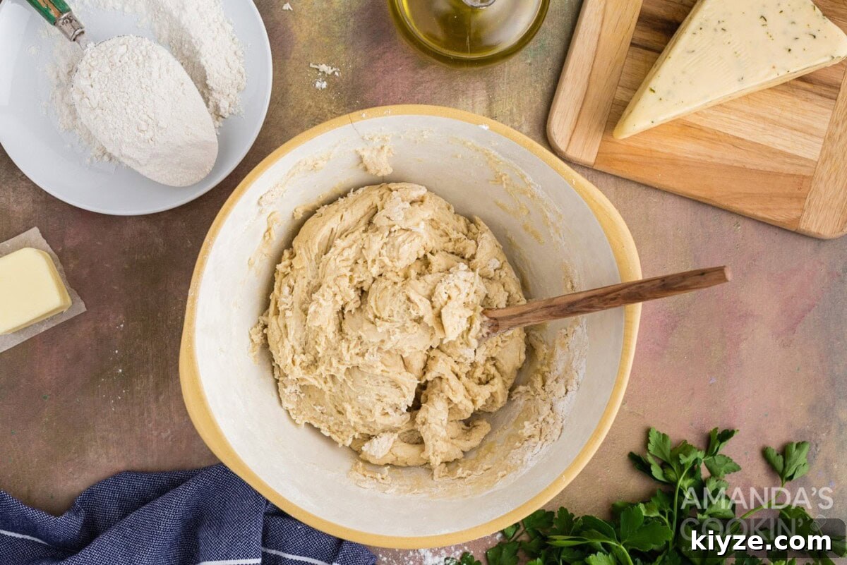 Garlic Herb Cheese Rolls Recipe — Soft, Cheesy, Irresistible 7 dough in a bowl with wooden spoon