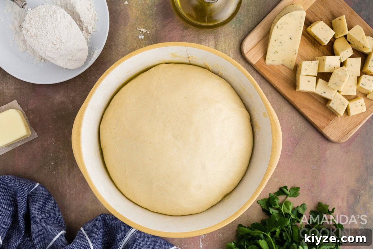 Garlic Herb Cheese Rolls Recipe — Soft, Cheesy, Irresistible 9 risen dough ball in a bowl