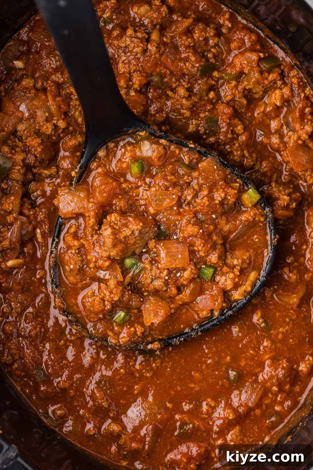 Slow Cooker No-Bean Chili Recipe for Tender, Flavorful Meat 9 closeup view of chili in black slow cooker with black ladle