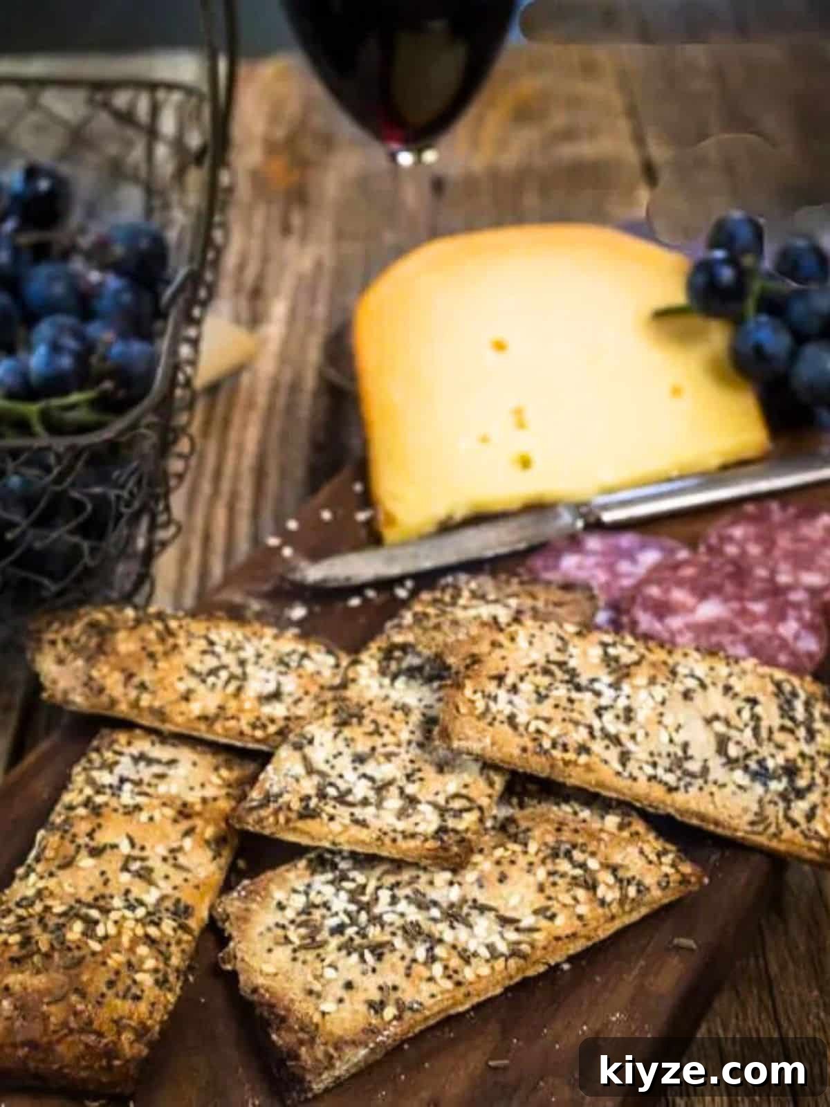Three-Seed Homemade Crackers Recipe for Crispy, Crunchy Snacks 14 A cutting board holding homemade seeded crackers and a block of Gouda cheese. Hostess At Heart