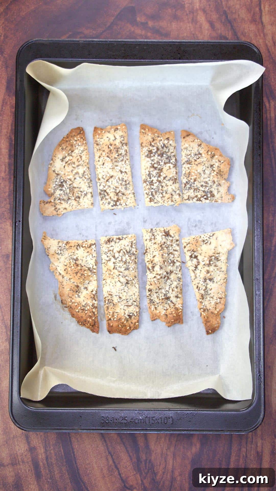 Three-Seed Homemade Crackers Recipe for Crispy, Crunchy Snacks 9 Baked crackers on a sheet pan.