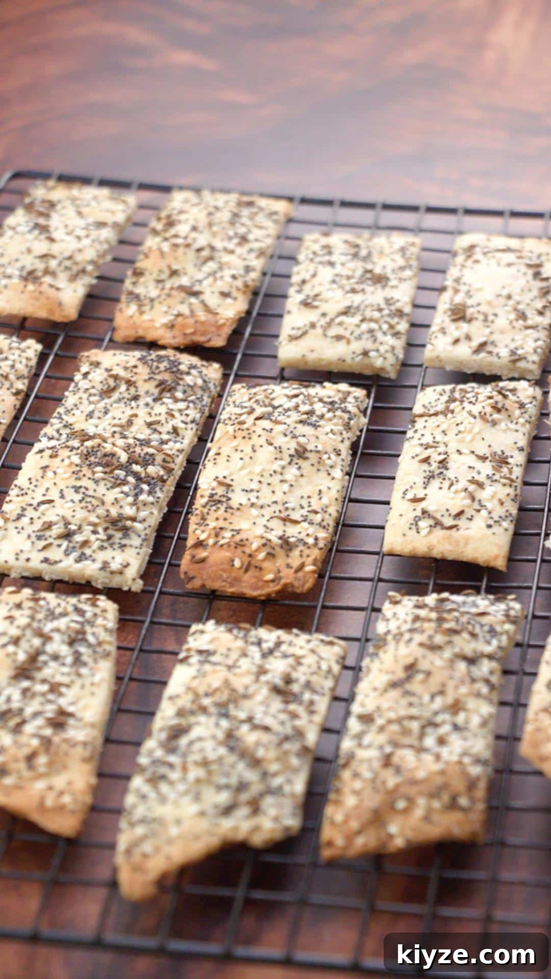 Three-Seed Homemade Crackers Recipe for Crispy, Crunchy Snacks 10 Homemade crackers on a cooling rack, vertical and distant view.