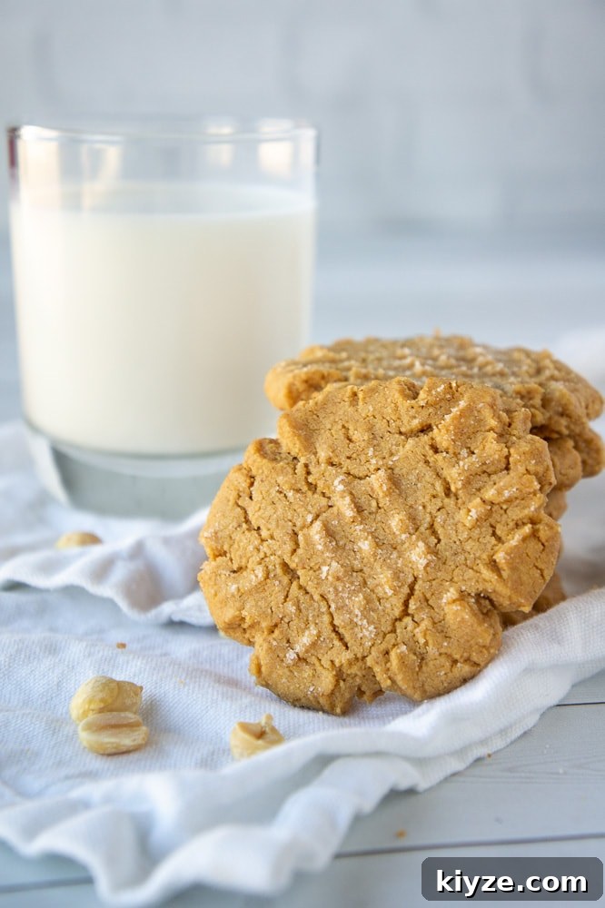 a stack of flourless peanut butter cookies in front of a glass of milk