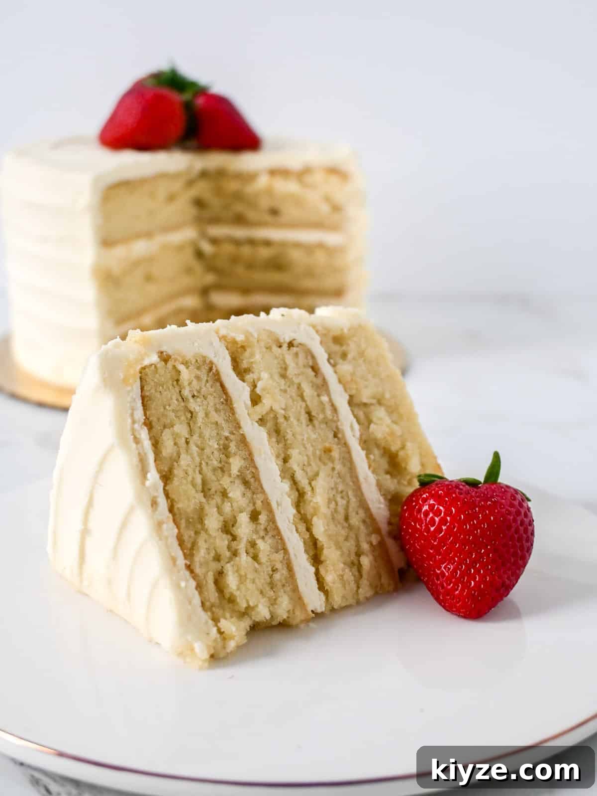 Moist Vanilla Cake Recipe Using the Reverse Creaming Method 2 slice of vanilla cake made using the reverse creaming method in front of the layered cake.