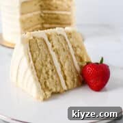 Moist Vanilla Cake Recipe Using the Reverse Creaming Method 18 closeup shot of vanilla cake made using the reverse creaming method with a fresh strawberry.
