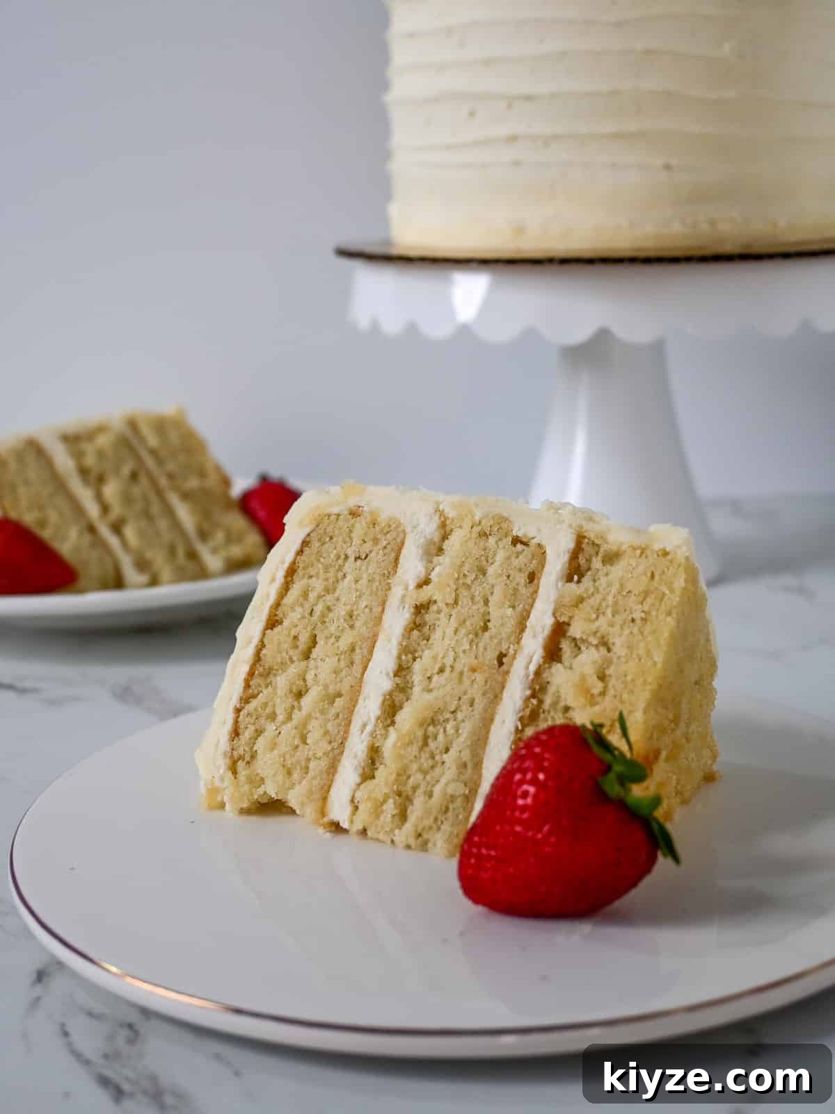 Moist Vanilla Cake Recipe Using the Reverse Creaming Method 3 two plates with vanilla white cake in front of a cake stand.