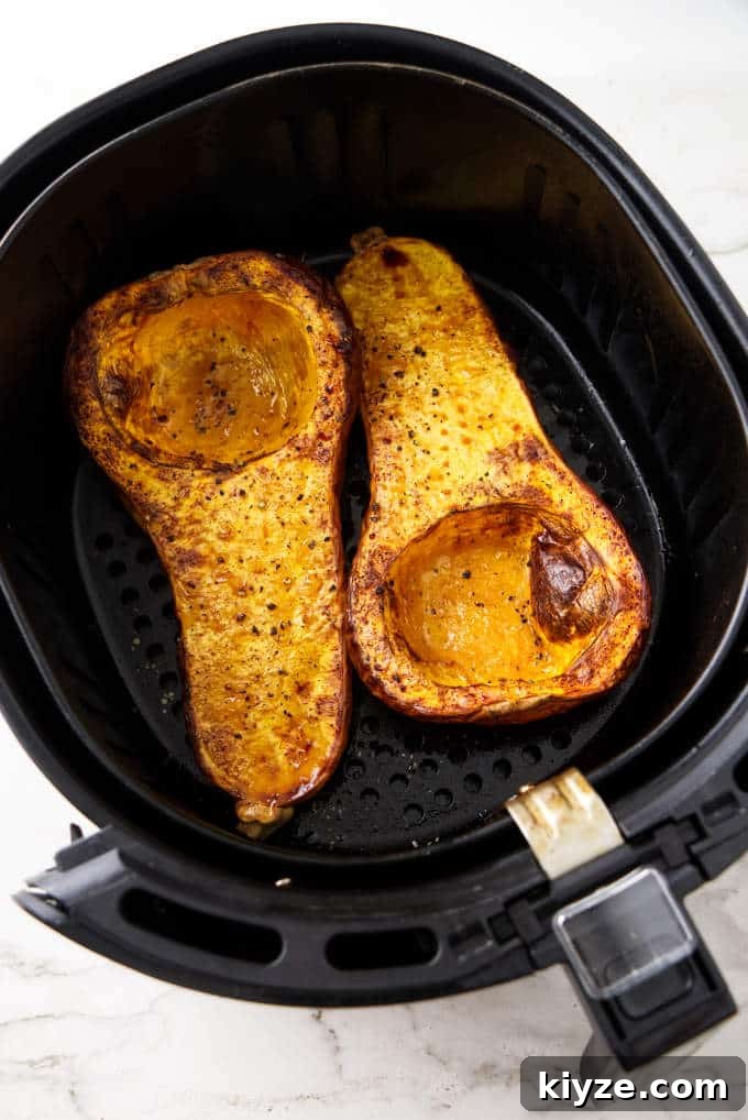 Air Fryer Butternut Squash with Sage Brown Butter Recipe 3 Two halves of a butternut squash in an air fryer basket.