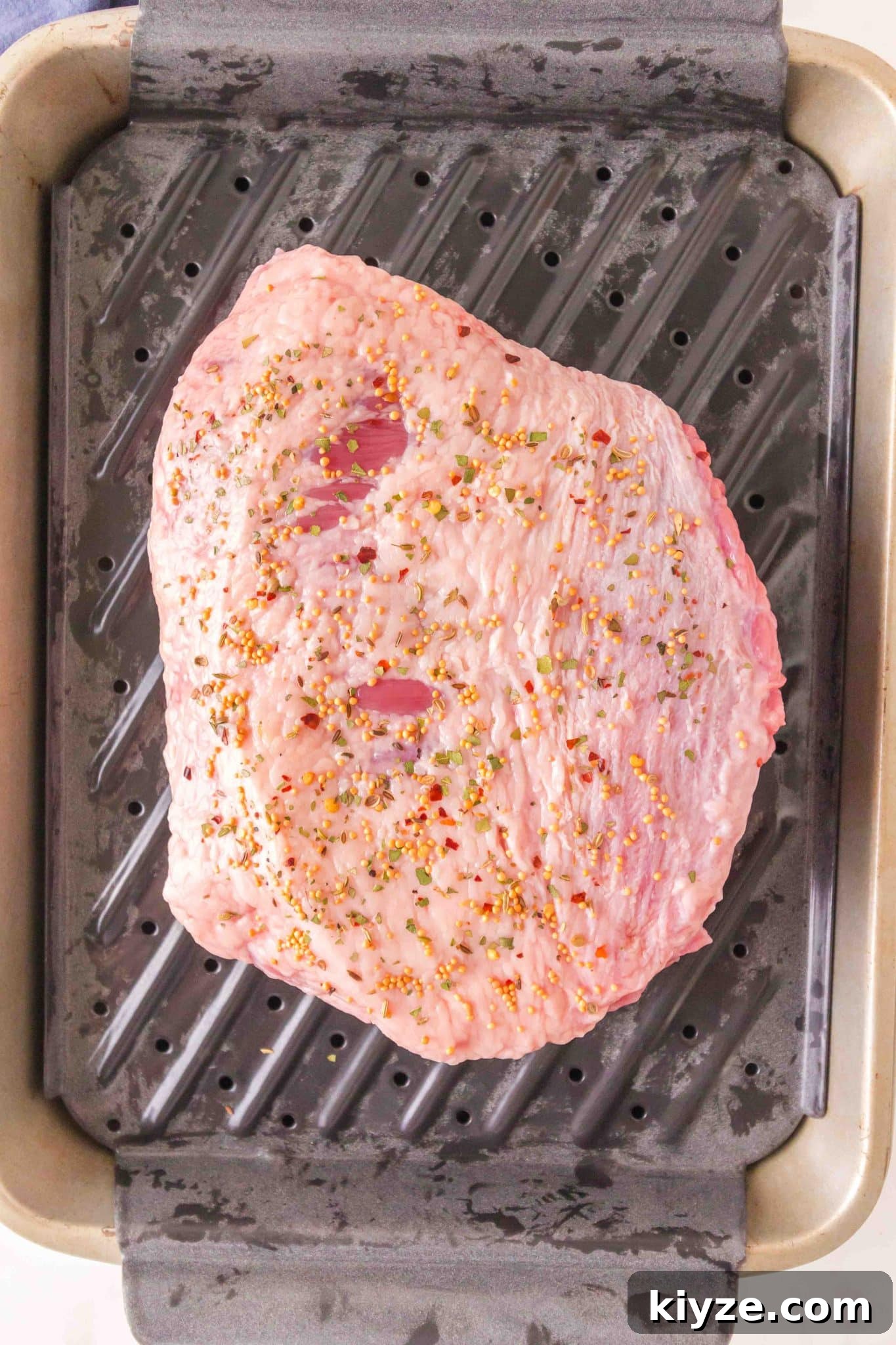 Juicy Oven-Baked Corned Beef Brisket Recipe 6 An unbaked beef brisket seasoned with corned beef slices in a baking dish ready to go into the oven. Hostess At Heart