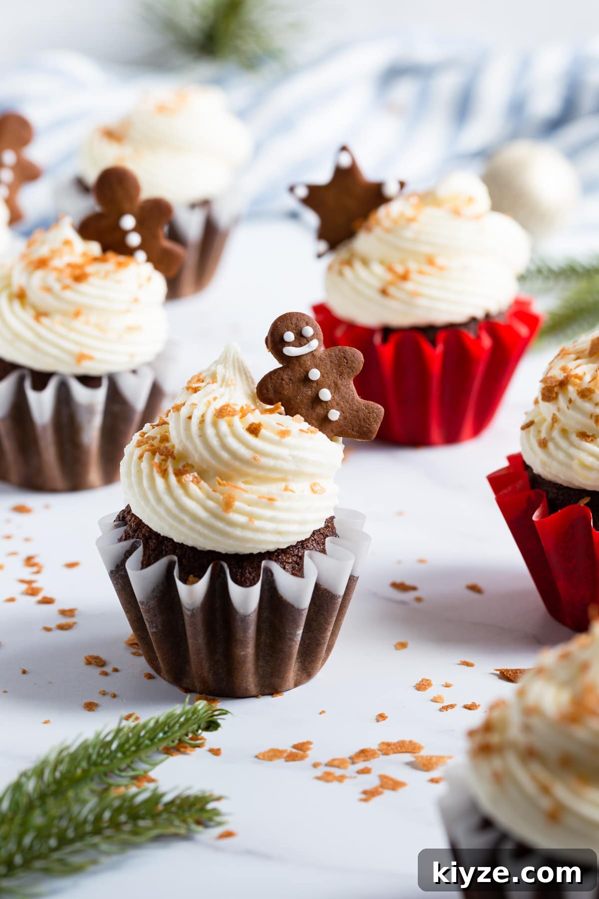 45 degree angle view at festive cupcake with frosting and small gingerbread cookie on top