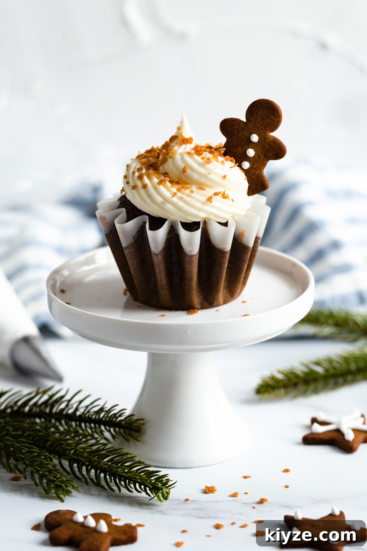 side shot of a single cupcake with cream cheese frosting on a cupcake stand