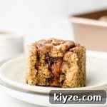 mini cinnamon roll on a white plate with a bite taken out of it