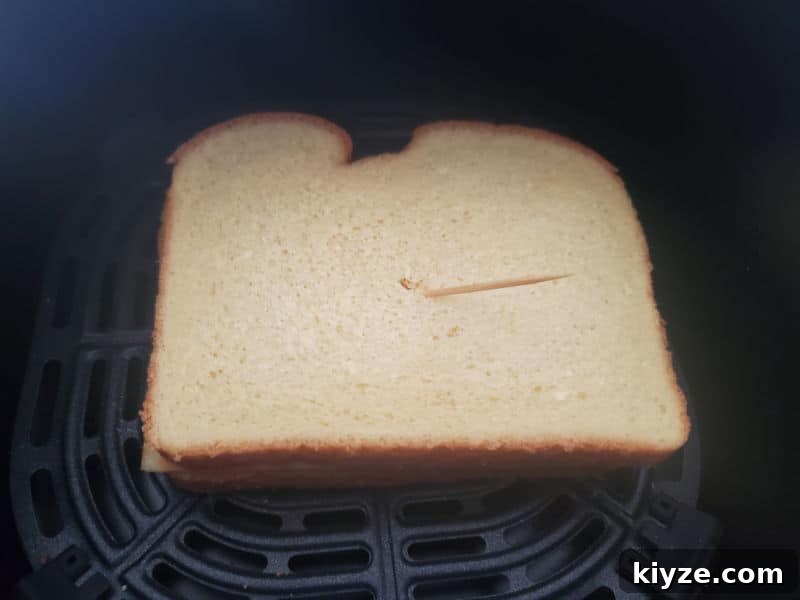 bread in an air fryer basket held together with a toothpick