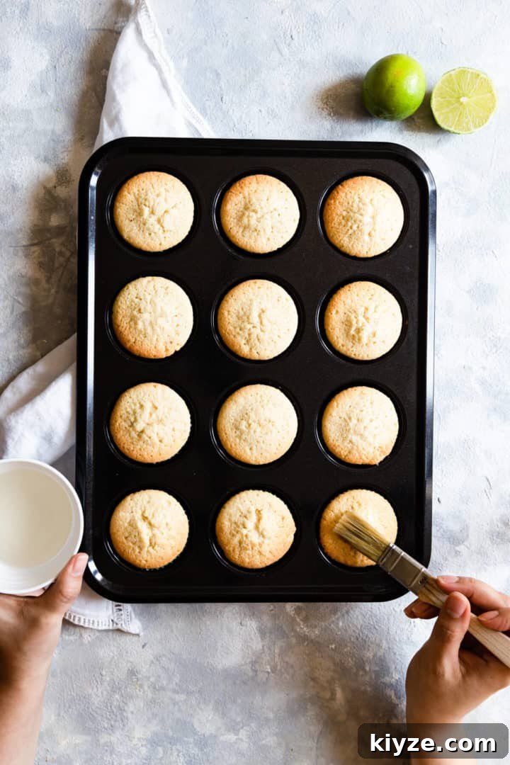 overhead shot of a person brushing cupcakes with syrup