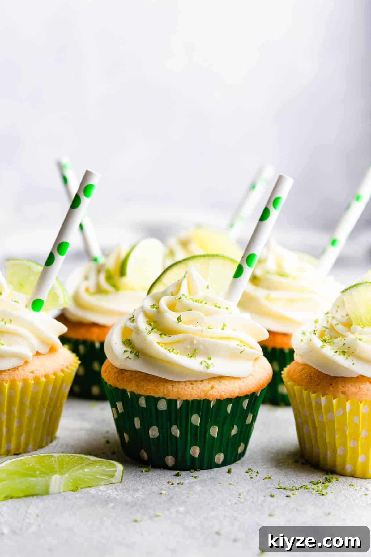 straight ahead shot of gin and tonic cupcakes with paper straws in buttercream