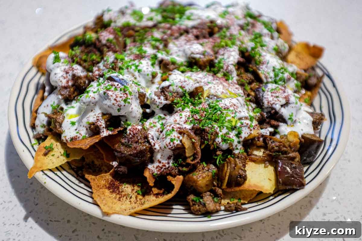 Lamb & Eggplant Fatteh a platter of Lamb & Eggplant Fatteh garnished with fresh parsley and sumac