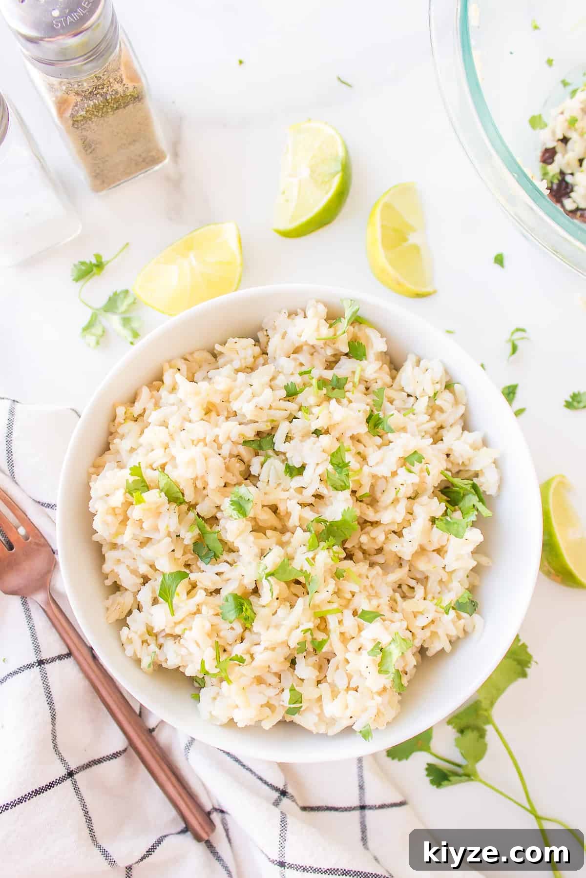 Homemade Fajita Seasoning Recipe That Beats Store-Bought 5 Cilantro lime brown rice in a bowl with a fork and lime wedges.