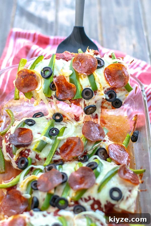 Low-Carb Supreme Pizza Chicken Bake 13 Supreme Pizza Chicken Bake Recipe Low Carb being served out of the dish pulling cheese and toppings with it