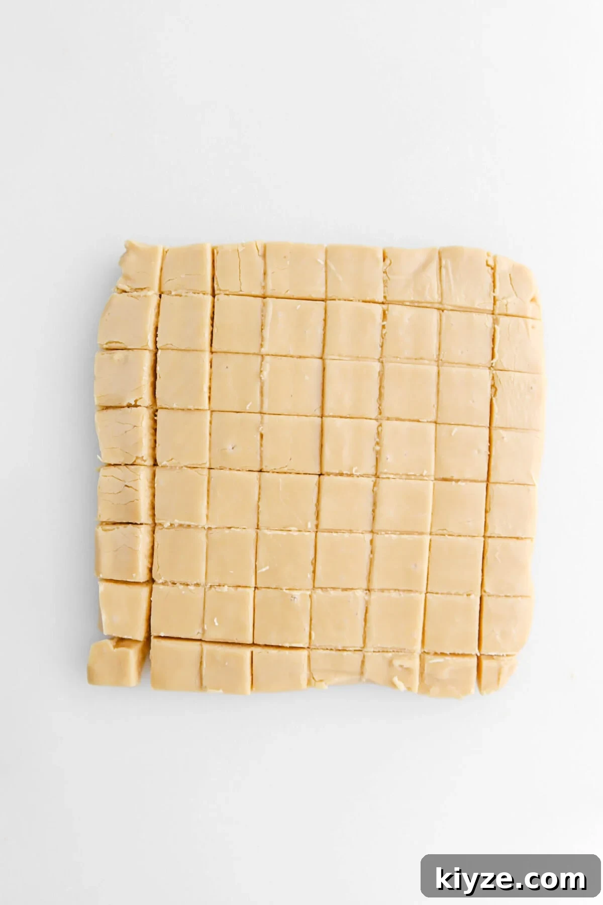 Old-Fashioned Maple Fudge Recipe 14 cut maple fudge on white surface.