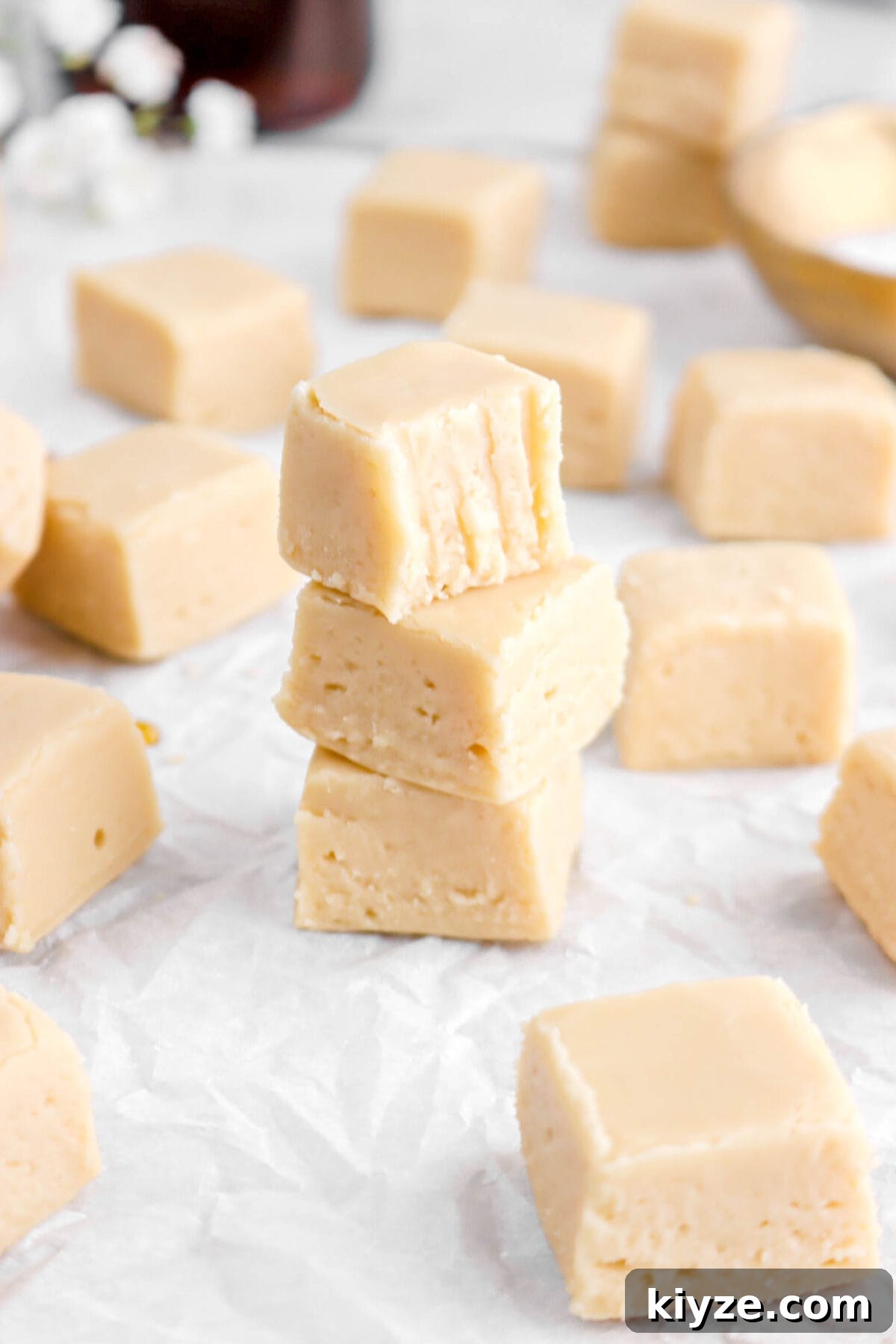 Old-Fashioned Maple Fudge Recipe 4 angled close up of three stacked maple fudge pieces with top piece missing a bite.