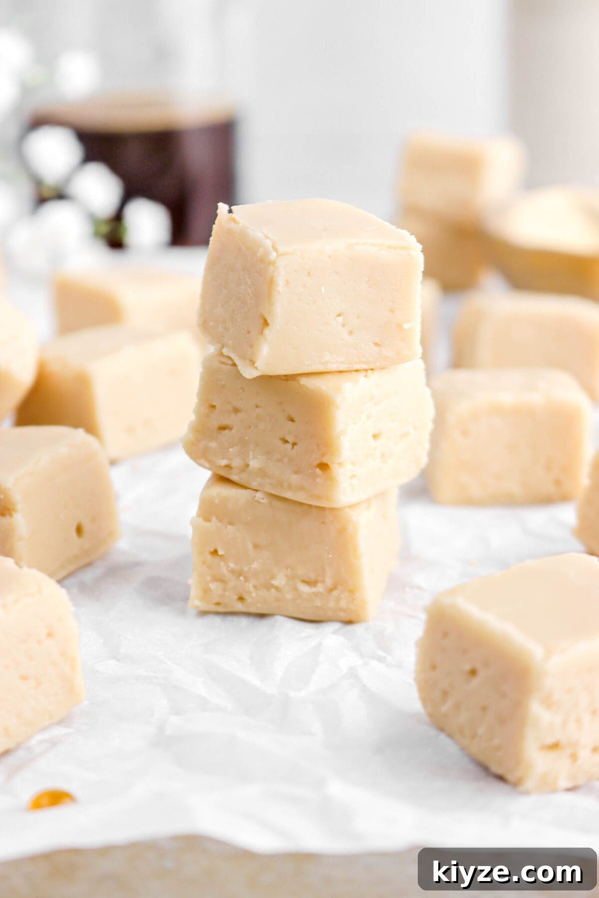 Old-Fashioned Maple Fudge Recipe 5 angled close up of maple fudge on parchment paper.