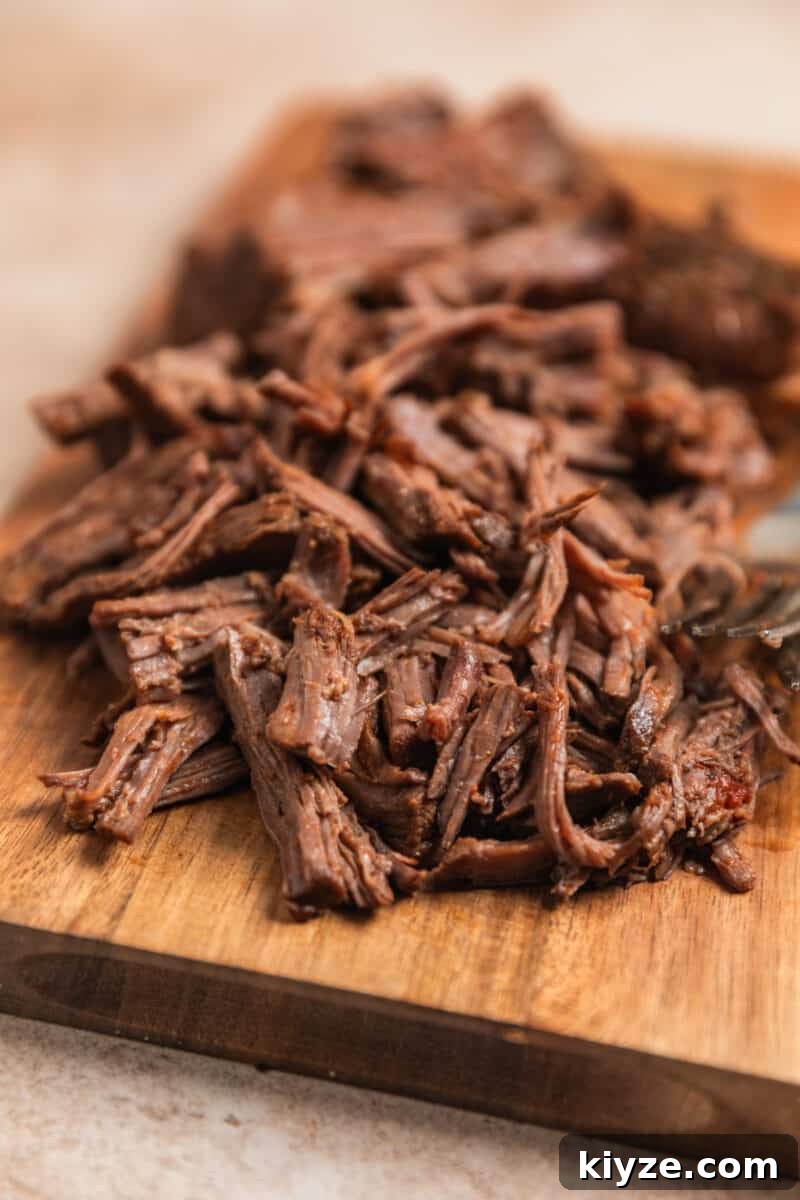 Slow Cooker Shredded Beef Chili Recipe 7 Shredded beef on cutting board.