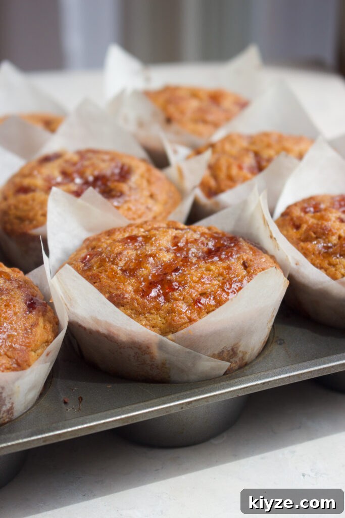 Peanut Butter and Jelly Muffins Recipe with Jam Swirl 4 Muffins cooling on a wire rack