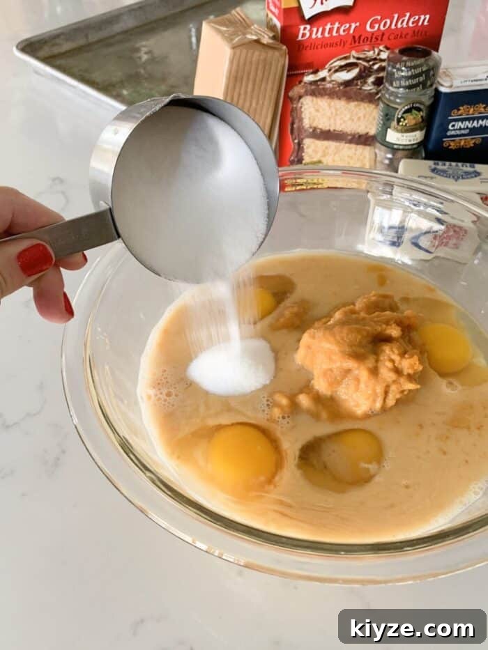 pouring sugar into mixing bowl for pumpkin bars
