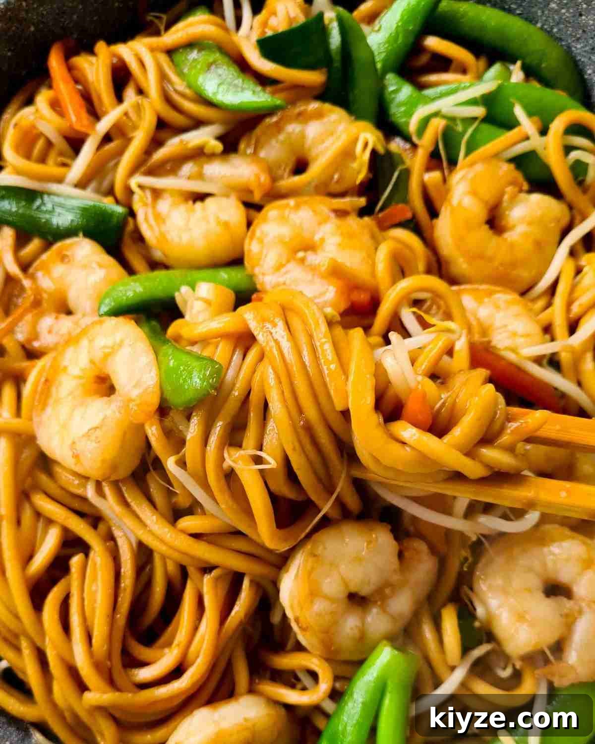 Wok Fried Prawn Noodles with Garlic and Chili 12 Close up of thick noodles with vegetables and prawns