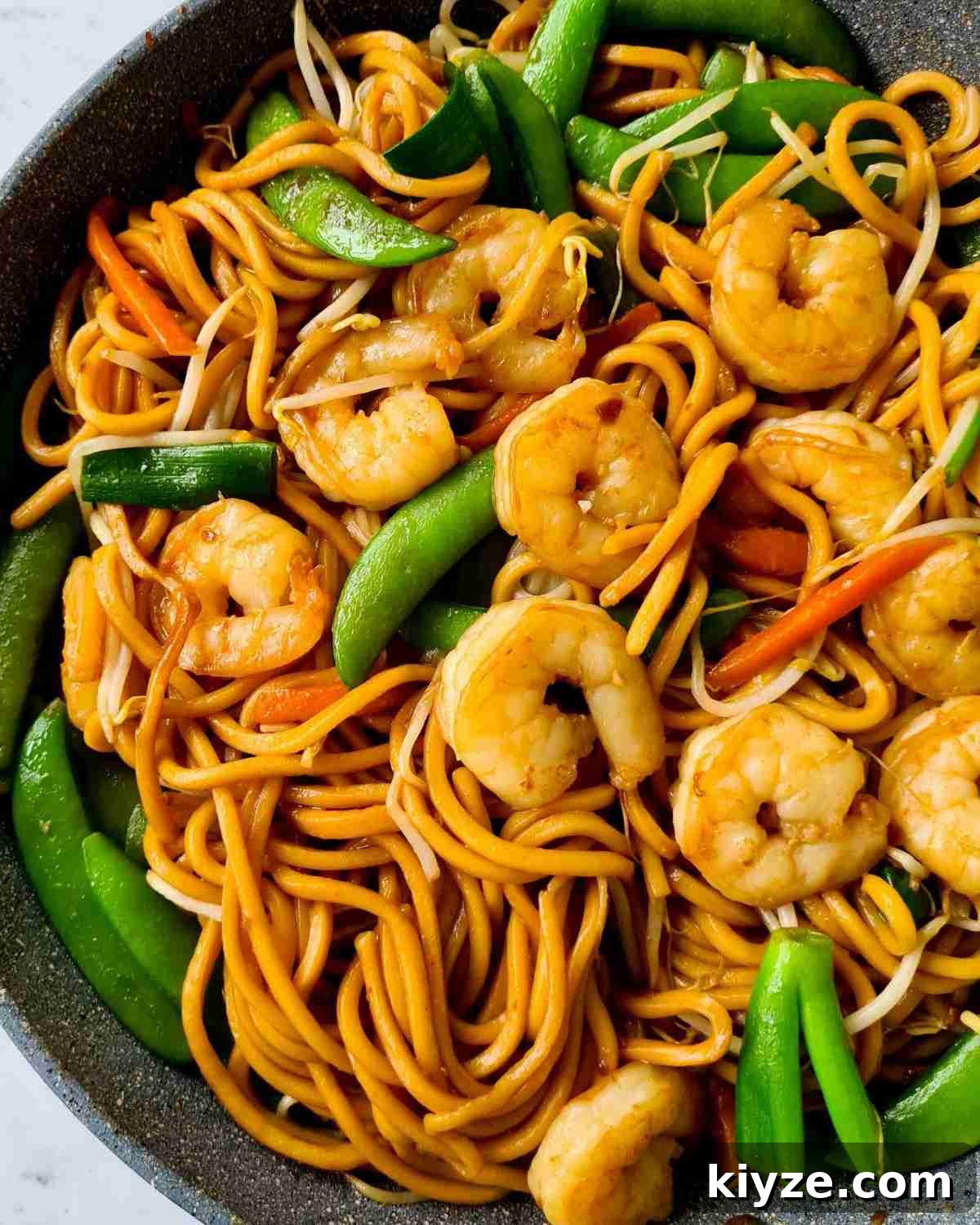 Wok Fried Prawn Noodles with Garlic and Chili 3 A large pan of thick noodles with peeled and deveined prawns and vegetables
