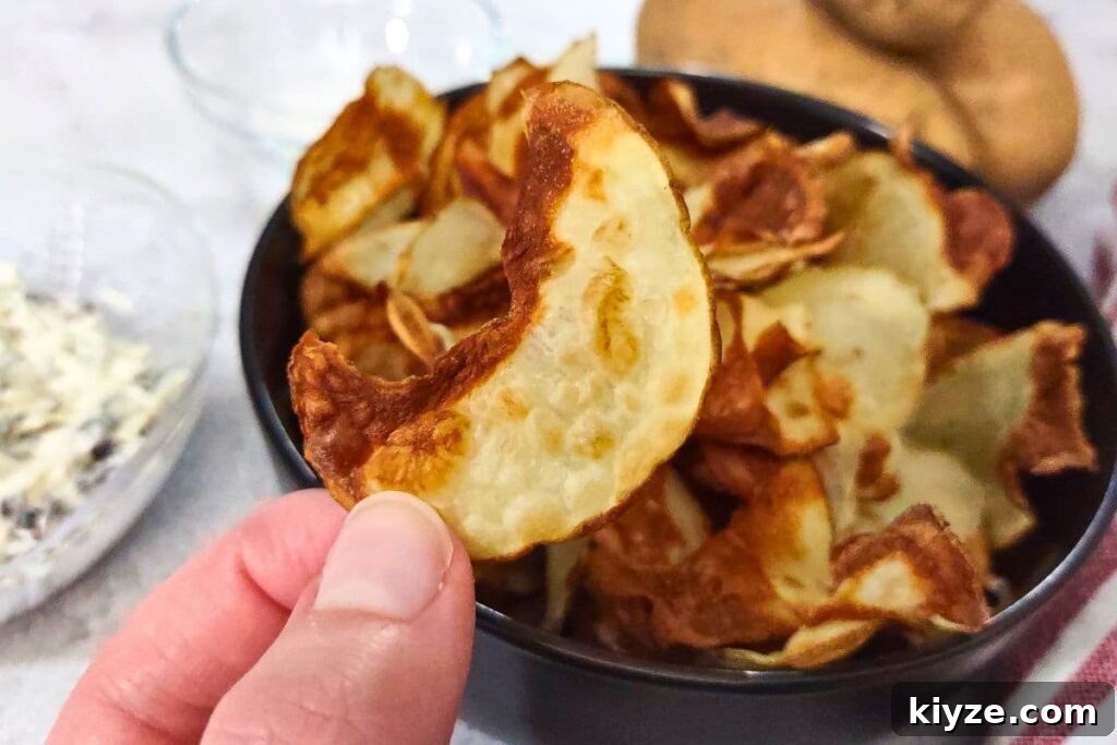 holding up a crispy ninja air fryer potato chip